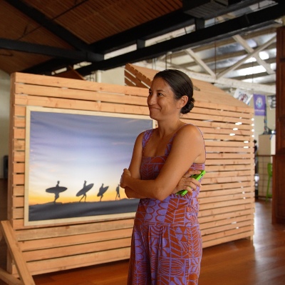 A woman standing in an office space surrounded by wooden panel accents