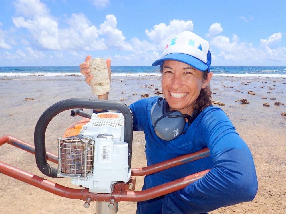 A woman researching reef quality on a sunny shoreline.