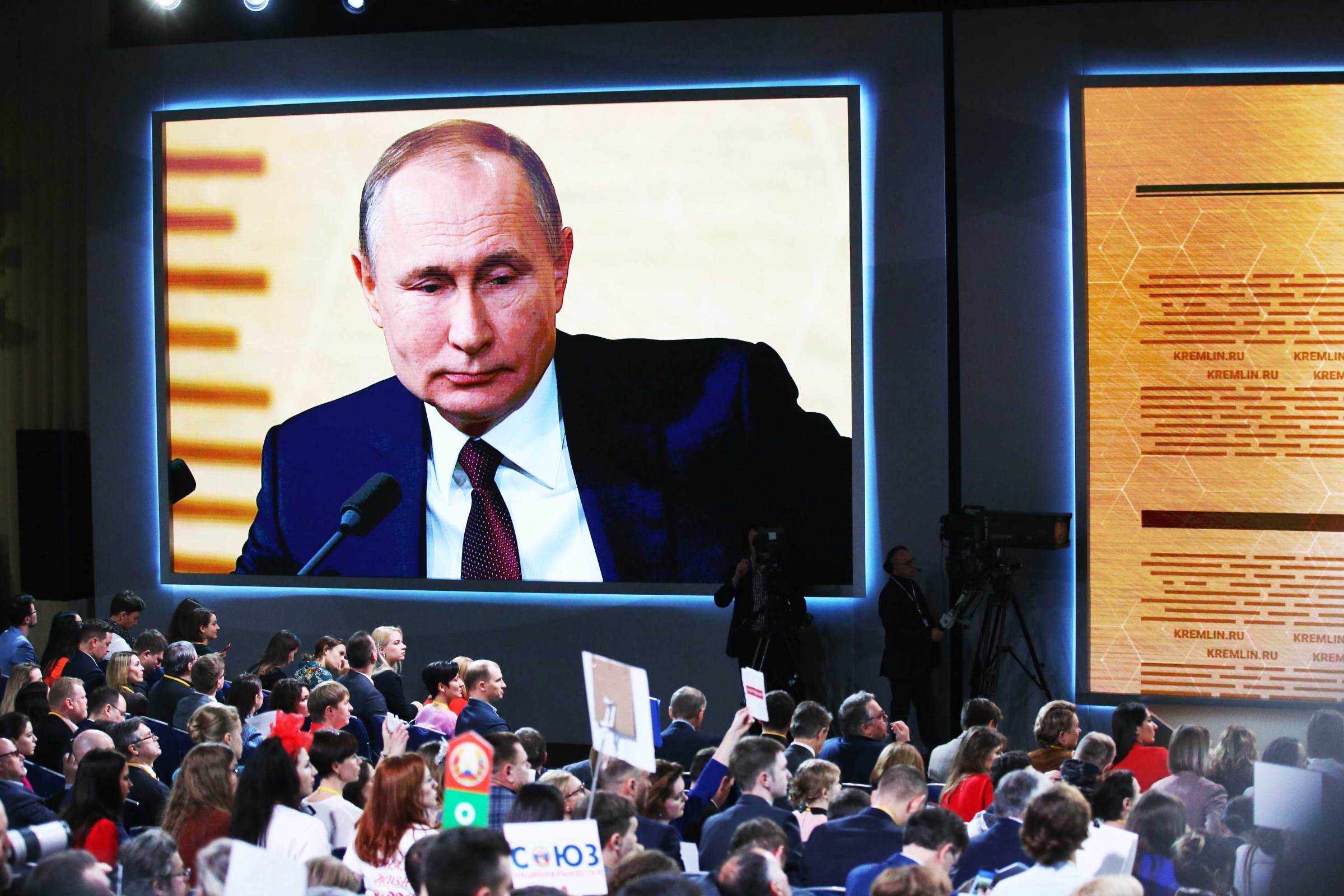 Russian President Vladimir Putin appears onscreen during a press conference in Moscow on December 19, 2019.