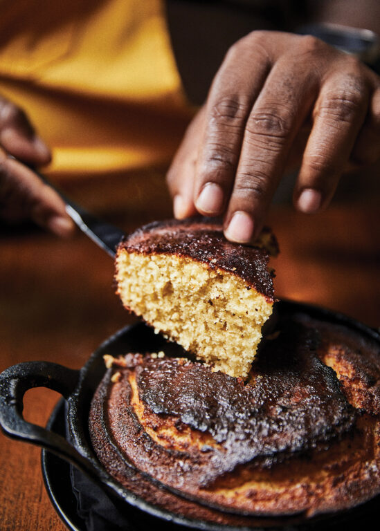 Man cutting a piece of cornbread