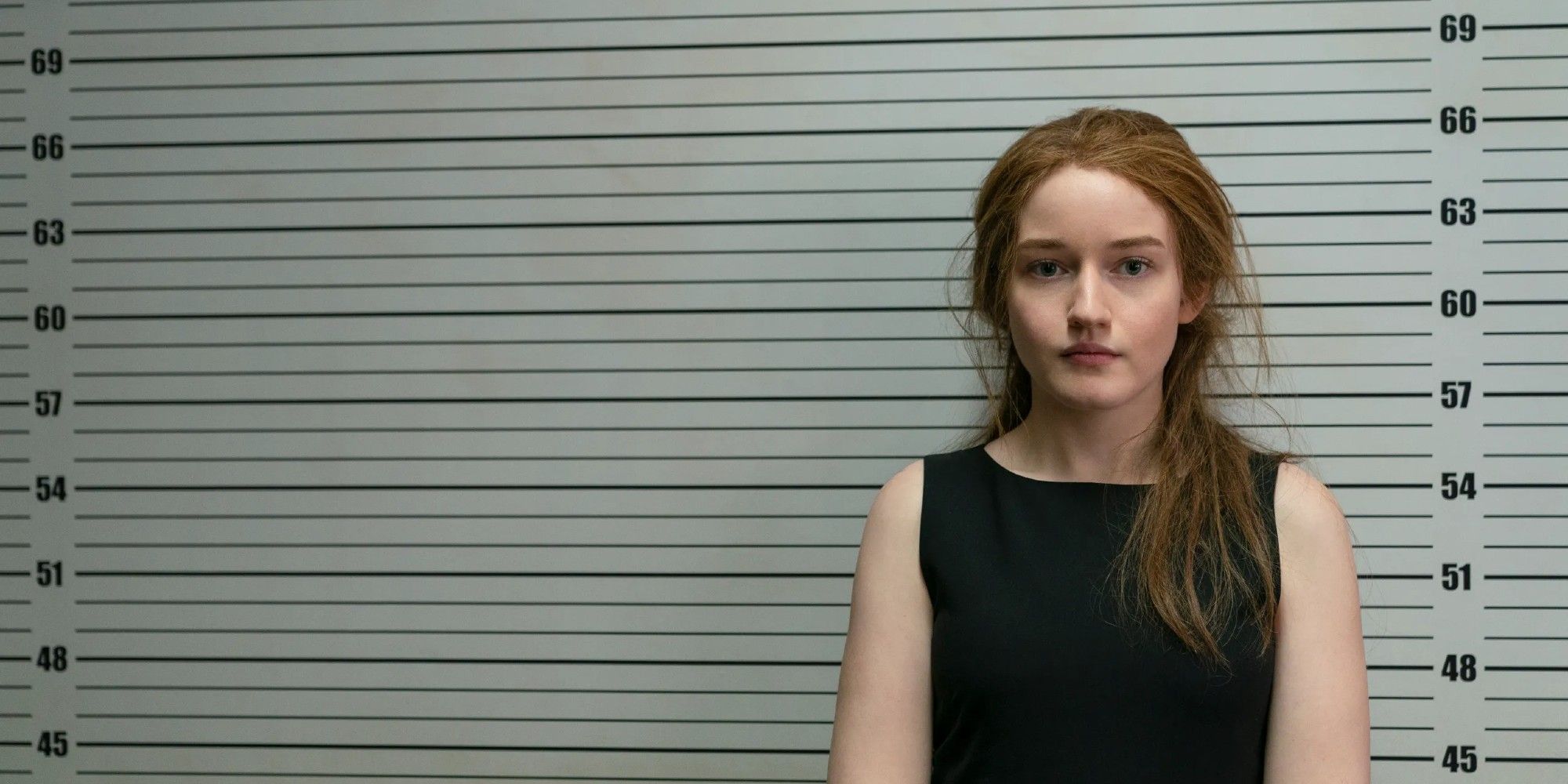Julia Garner as Anna Delvey posing for a mugshot